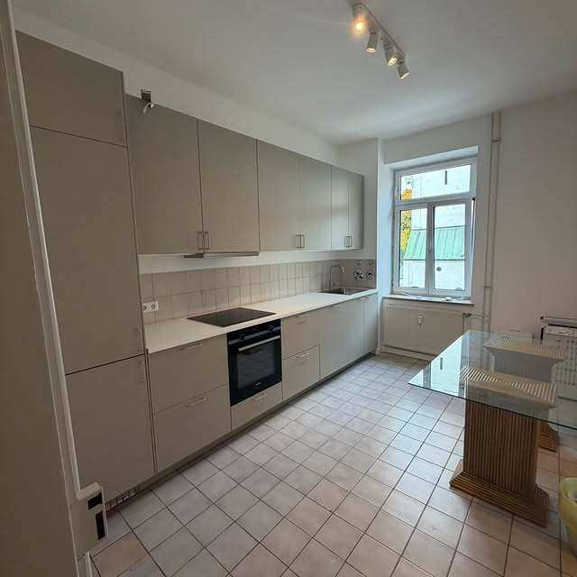 Beige-graue Einzeilenküche mit weißer Arbeitsplatte