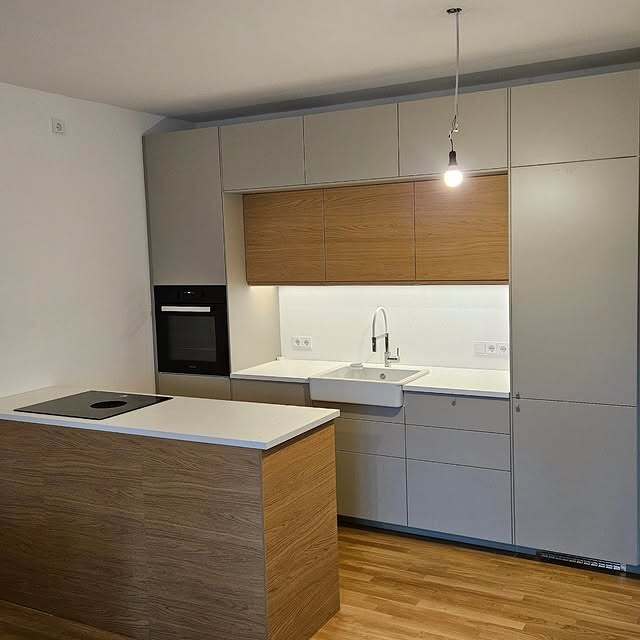 Moderne Küche mit Holzinsel, grauer Front und Hängelampe