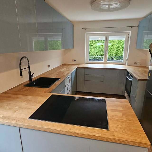 Hochglanz U-Küche in Grau-Blau mit Eichenarbeitsplatte